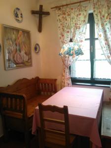 uma sala de jantar com uma mesa e uma cruz na parede em Orgona Ház em Szécsény