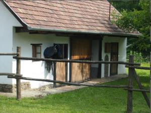 una casa con una valla de madera delante de ella en Orgona Ház en Szécsény