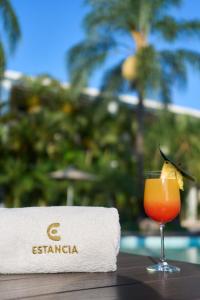 a drink sitting on a table next to a towel at Hotel Estancia Business Class in Guadalajara