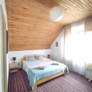 a bedroom with a large bed with a wooden ceiling at Attico Viva in Plitvička Jezera