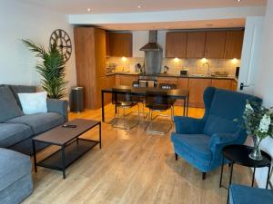 een woonkamer met een bank en een tafel bij Lux Waterfront 2 bed Apt, V&A 10min walk, St Andrew's Golf 25min drive in Dundee