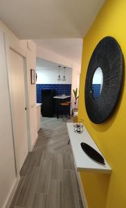 een woonkamer met een gele muur en een spiegel bij The2G Beach Apartment in Torremolinos