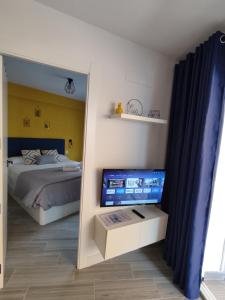een slaapkamer met een bed en een flatscreen-tv bij The2G Beach Apartment in Torremolinos