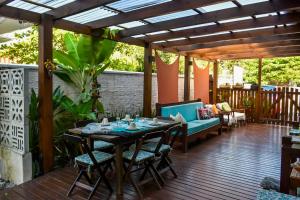 a patio with a table and chairs on a deck at Pérola de Bombinhas in Bombinhas