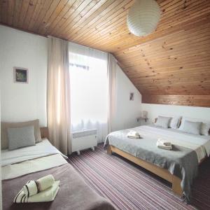 1 dormitorio con 2 camas y ventana grande en Attico Viva, en Lagos de Plitvice