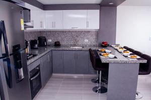 a kitchen with a counter with plates of food on it at HERMOSO APARTAMENTO AMOBLADO CENTRO DE BUGA in Buga