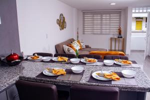 een keuken met een tafel met borden met eten erop bij HERMOSO APARTAMENTO AMOBLADO CENTRO DE BUGA in Buga