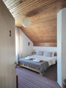 a bedroom with a large bed with a wooden ceiling at Attico Viva - Self Check-in in Plitvička Jezera