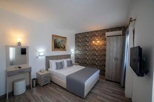 pokój hotelowy z łóżkiem i telewizorem w obiekcie Queen Boutique Hotel w mieście Bitez