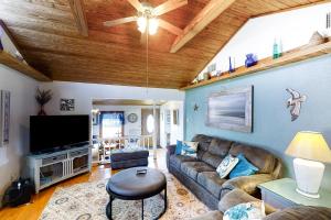 a living room with a couch and a flat screen tv at Crescent Beach Cottage in Saint Augustine
