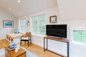 a living room with a large flat screen tv at Coveside Carriage House in Boothbay Harbor