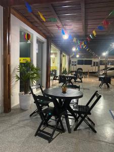 a patio with tables and chairs in a building at Pousada Sertaneja in Canindé de São Francisco