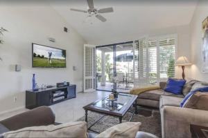 a living room with a couch and a tv at Private Country Club Condo on awesome golf course! in Palm Desert