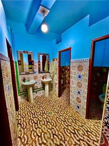 a bathroom with three sinks and mirrors in a room at Riad dar Ahlam in Aït Baha
