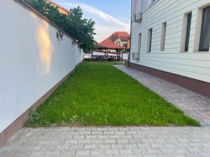 a yard of grass next to a building at Iarca Inn in Bucharest