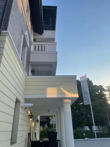 a white house with a white column and a flag at Iarca Inn in Bucharest