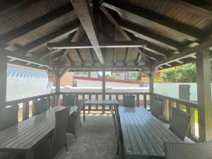 a patio with wooden tables and chairs and a roof at Iarca Inn in Bucharest