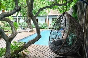 a hammock hanging from a tree next to a pool at Hare Nua Hotel Boutique in Hanga Roa +86 photos