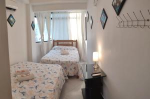 1 dormitorio con 2 camas y ventana en Casa Linda, en Santa Marta