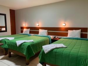 a hotel room with two beds with green sheets at Hotel Herusalen in Arequipa