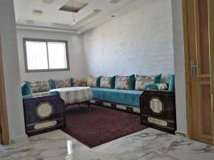 - un salon avec un canapé bleu et une fenêtre dans l'établissement Appartement bien situé Dahomey city . Bahia beach, à Bouznika