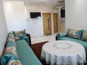 - un salon avec deux canapés bleus et une table dans l'établissement Appartement bien situé Dahomey city . Bahia beach, à Bouznika