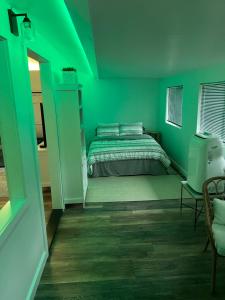 a green bedroom with a bed and a chair at Hawaii Getaway in Holualoa