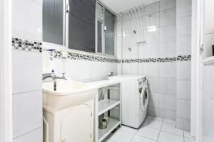 a white bathroom with a sink and a washing machine at QUARTO INTEIRO com banheiro exclusivo Coração de Florianópolis in Florianópolis +19 photos