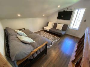 1 dormitorio con 1 cama y 1 sofá en una habitación en Cabaña con tinaja en bosque Valdiviano en Valdivia