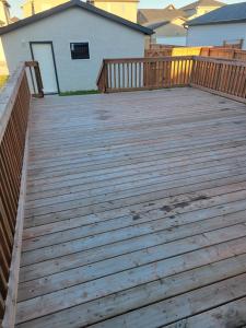 a wooden deck with a fence and a house at House of Love in Winnipeg