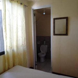a bathroom with a toilet and a door with a window at Just Inn in El Nido +77 photos