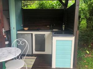 uma cozinha exterior com um fogão e uma mesa em Charmant bungalow avec piscine em Saint-Joseph