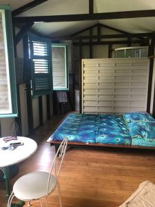 um quarto com uma cama, uma mesa e uma cadeira em Charmant bungalow avec piscine em Saint-Joseph