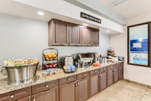a large kitchen with wooden cabinets and a counter top at Baymont by Wyndham Loveland - Fort Collins Area in Loveland