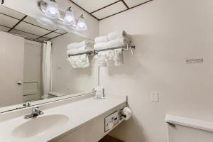 a white bathroom with a sink and a mirror at Baymont by Wyndham Loveland - Fort Collins Area in Loveland
