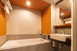 a bathroom with a bath tub and a sink at Grand Hotel Vientiane in Vientiane