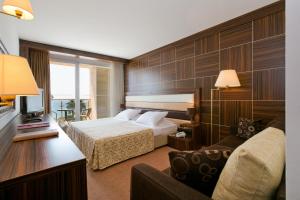 a hotel room with a bed and a couch at Hotel Palas in Petrovac na Moru