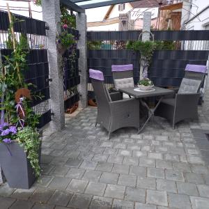 a patio with a table and chairs and a fence at Gelis Ferienwohnung in Aichstetten
