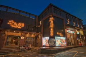 a building with neon signs on the side of it at Fenchihu Hotel in Fenchihu