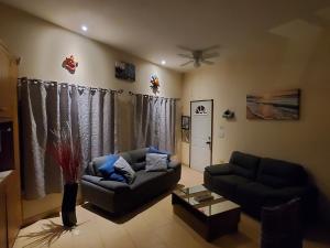 sala de estar con 2 sofás y ventilador de techo en Hacienda Gallardos 104-1, en San Carlos