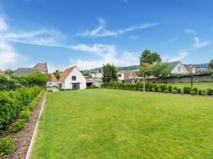 une grande pelouse dans une cour avec des maisons dans l'établissement Lovely holiday home in Mont de l Enclus with garden, à Mont-de-l'Enclus