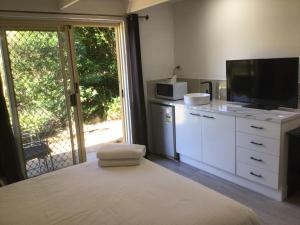 a kitchen with a white refrigerator and a white microwave at Buderim Fiesta Motel in Tanawha