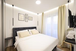 1 dormitorio con cama blanca y ventana en Olive Residence, en Zadar