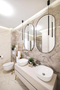 a bathroom with two sinks and two mirrors at Olive Residence in Zadar