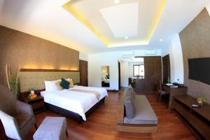 a hotel room with a bed and a television at Coron Soleil Garden Resort in Coron