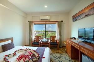 ein Hotelzimmer mit einem Bett mit Kuchen drauf in der Unterkunft E-outfitting Golden Country Hotel in Mandalay