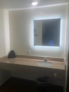 y baño con lavabo y espejo. en Red Lion Inn and Suites La Pine, Oregon, en La Pine
