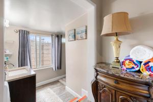 a bathroom with a sink and a lamp on a dresser at Oceanside Rocks Family Vacation Home in Oceanside +50 photos