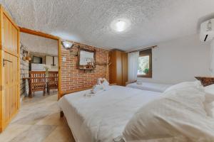 1 dormitorio con 2 camas y pared de ladrillo en Markovic Village Apartments, en Ulcinj