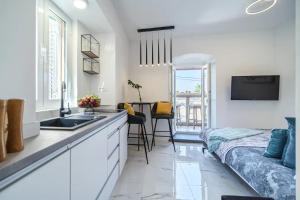 eine Küche und ein Wohnzimmer mit einem Waschbecken und einem Sofa in der Unterkunft Apartment Vin - sea promenade in Supetar